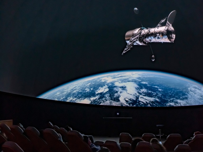 Patrons of the NKU's Haile Planetarium watch a captivating program on the large dome screen.