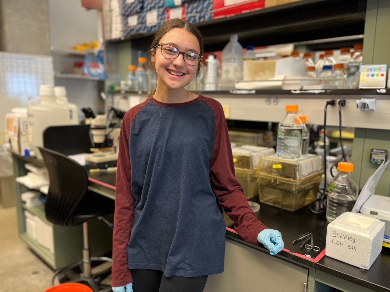 An NKU STEM scholarship recipient smiles while conducting research in the lab.