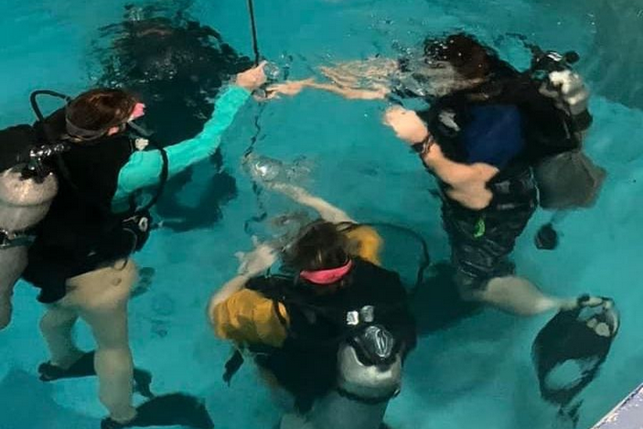 SCUBA Club Student club members practice diving in a swimming pool.