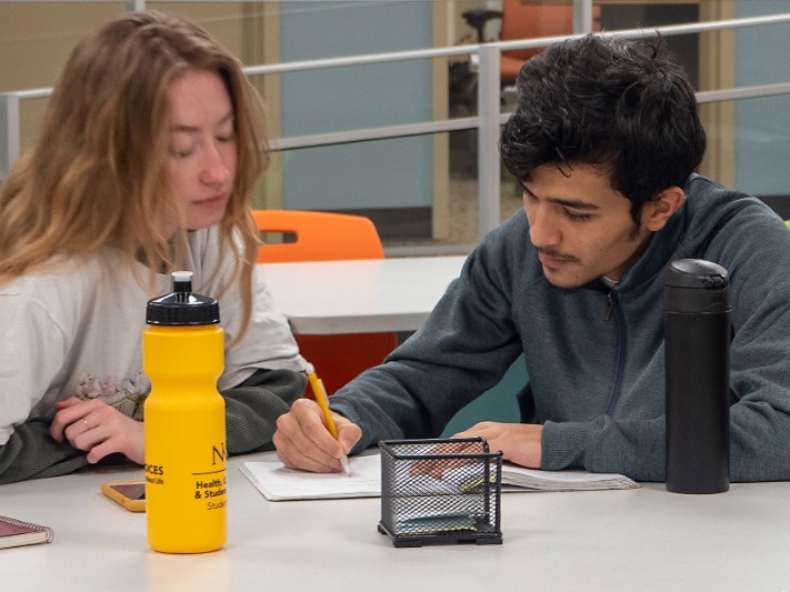 A paid student tutor helps a fellow NKU student with mathematics.