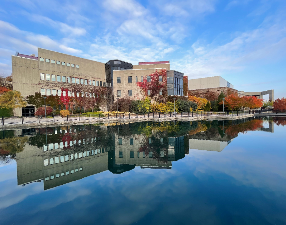Image of SOTA building with blue sky and reflection in lake