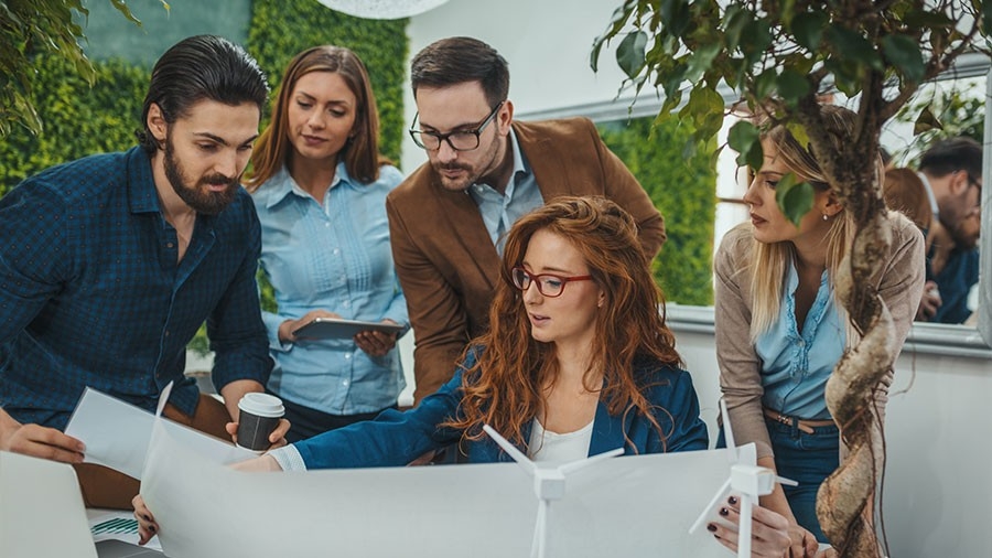 A group of people gather around a collection of documents